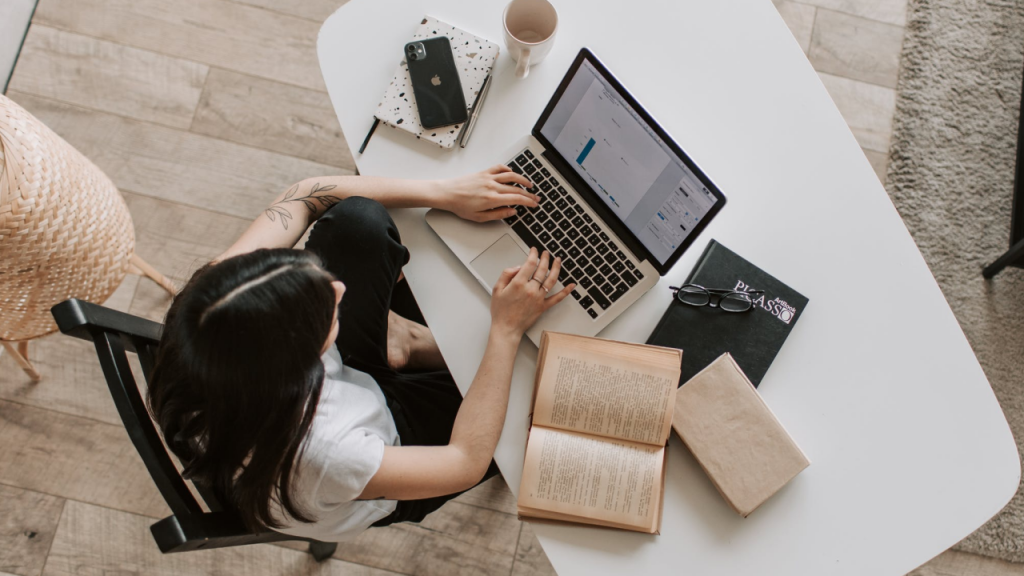 woman reading and writing on laptop