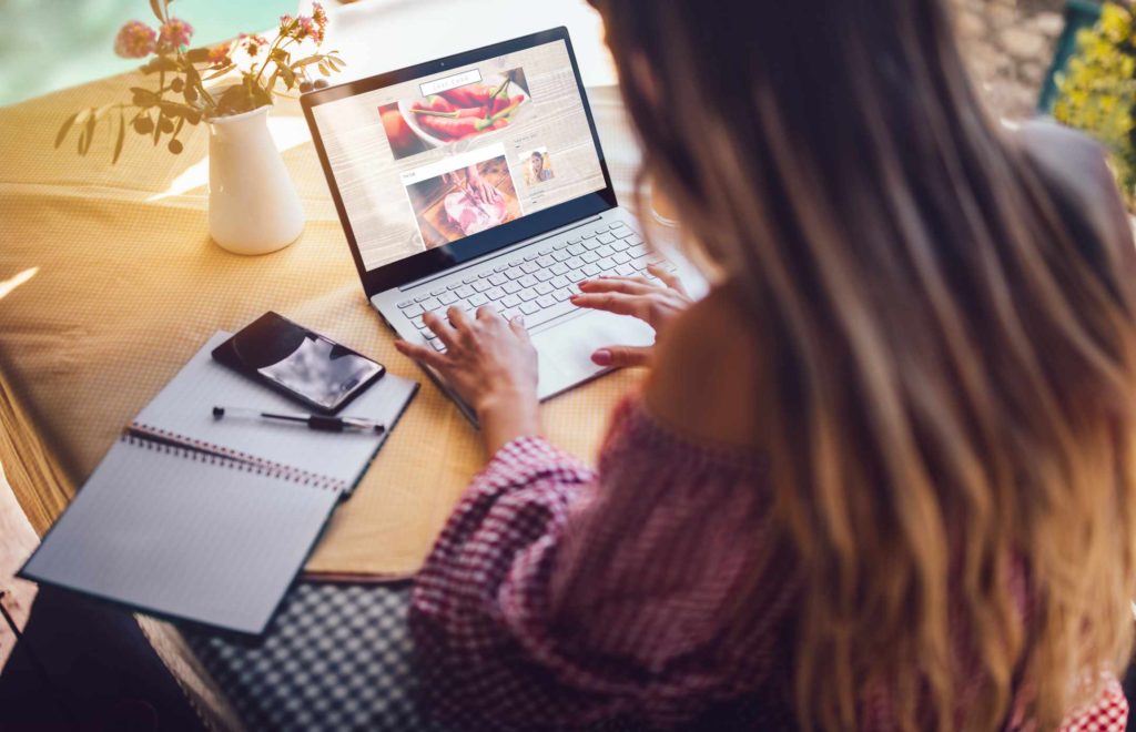 woman writing on lap top